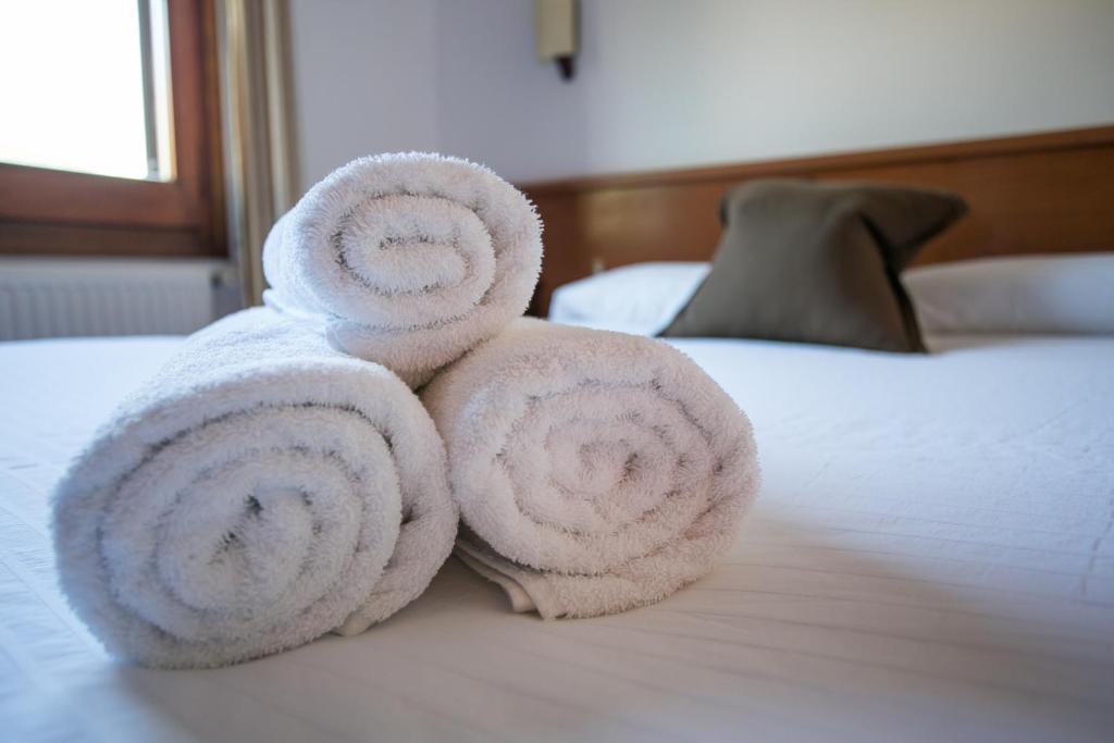 una pila de toallas sentadas encima de una cama en Fonda Barris, en Joanetes