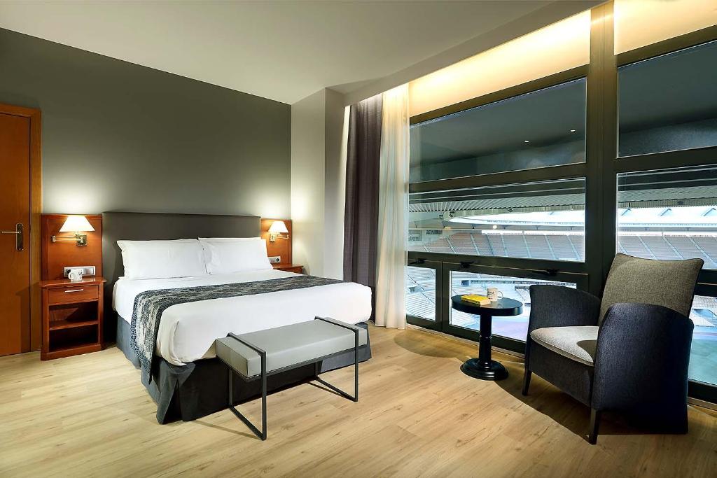 Habitación de hotel con cama y silla en Exe Isla Cartuja, en Sevilla