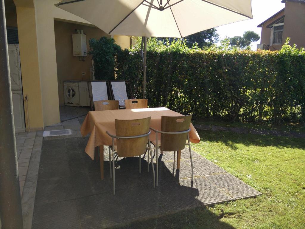 una mesa y sillas con una sombrilla en un patio en Il Palco residence, en Cinquale