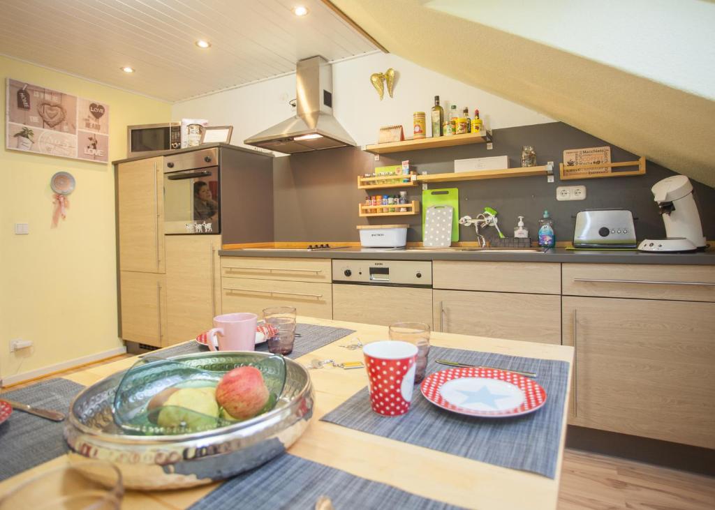 a kitchen with a table with a bowl of fruit on it at Wohlfühloase am Bikepark und Skigebiet, 2 Schlafzimmer, abschließbarer Fahrradkeller in Winterberg