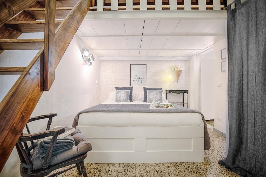 a bedroom with a large white bed and a chair at Sweet Campo de Fiori in Rome