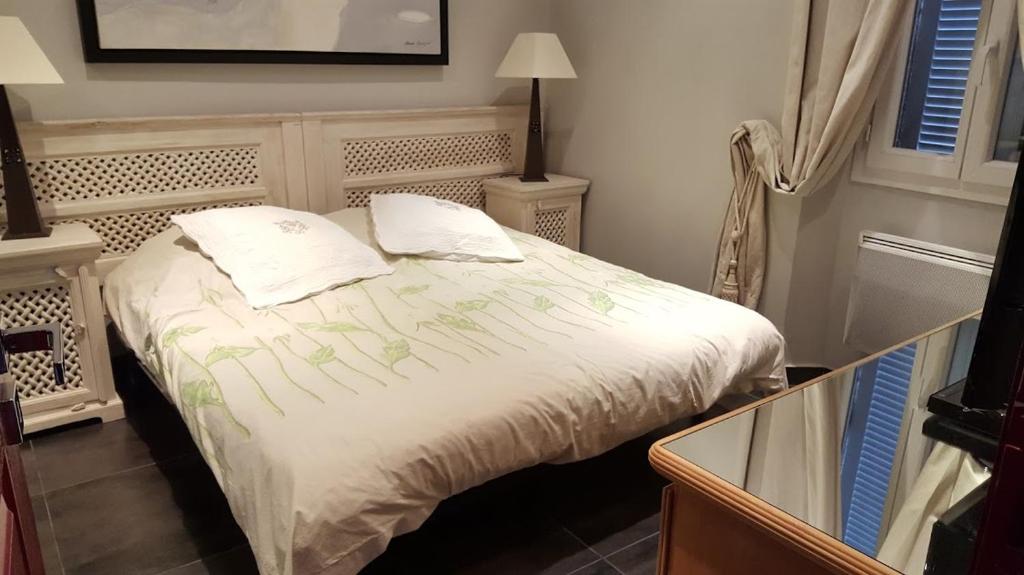- un lit avec 2 oreillers dans une chambre dans l'établissement la Tourraque, à Antibes