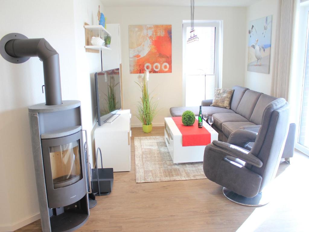 a living room with a couch and a wood stove at Ferienwohnung Silbermöwe im Kirschgarten 1 in Kellenhusen