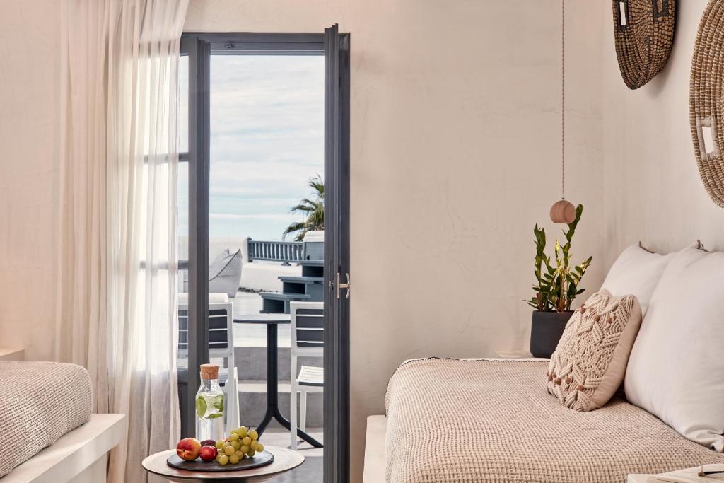 a bedroom with a bed and a table with a plate of fruit at Parian Boutique Hotel in Naousa