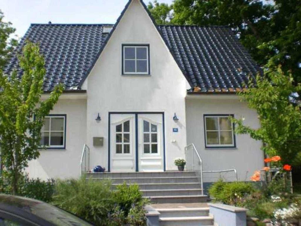 una casa blanca con escaleras delante en Ferienwohnung Schuett _ Objekt 259, en Rostock