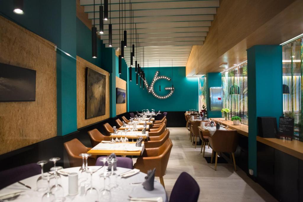 a dining room with tables and chairs and blue walls at Vanilla Garden Boutique Hotel - Adults Only in Playa de las Americas