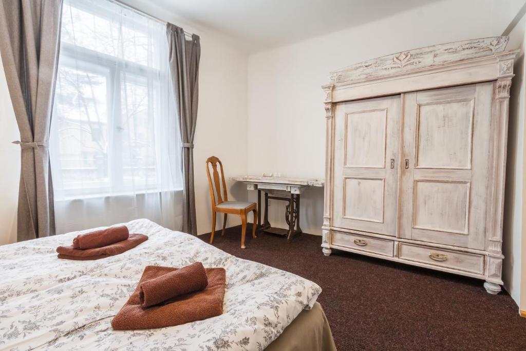 a bedroom with a bed and a dresser and a desk at Riga Academic Guest House in Riga