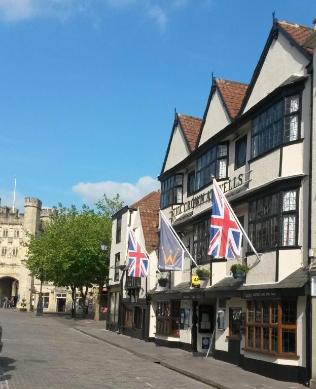 un edificio con banderas británicas en una calle en The Crown at Wells, Somerset en Wells