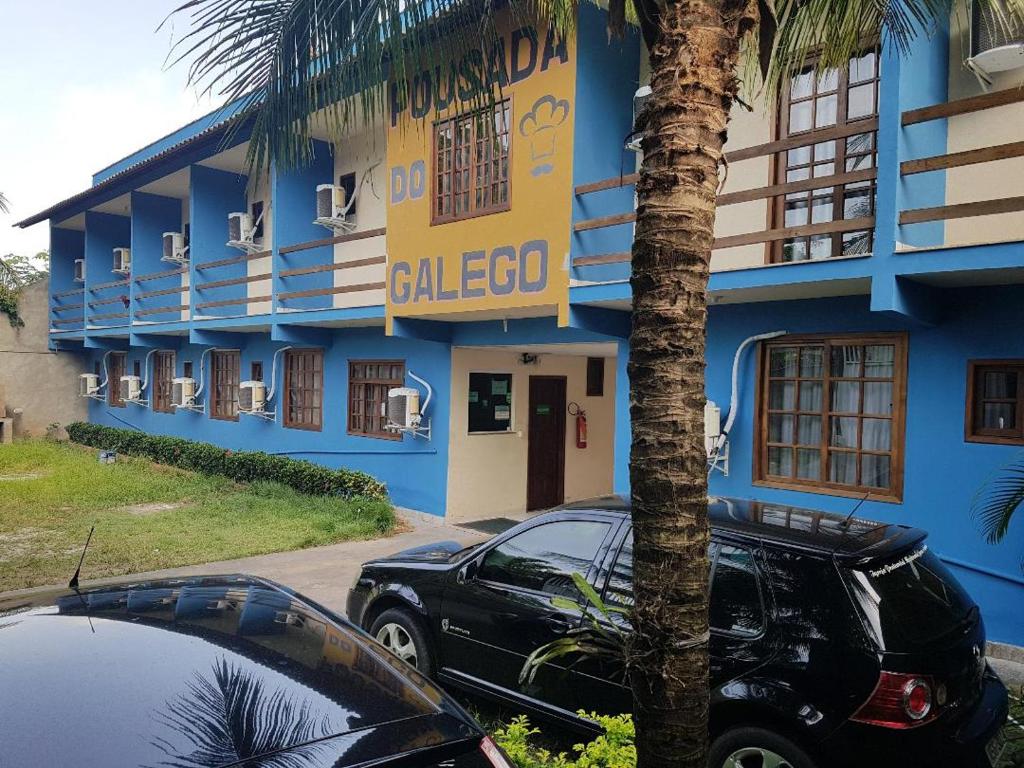 a blue building with a car parked in front of it at POUSADA DO GALEGO in Itaguaí