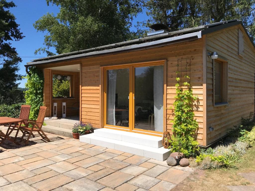 a tiny house with a patio and a table at Ferienhaus Ilfeld in Ilfeld