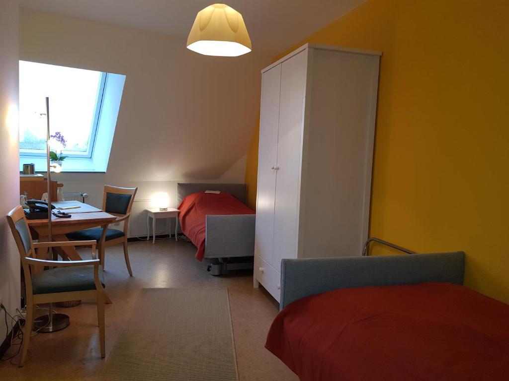 1 Schlafzimmer mit 2 Betten, einem Tisch und einem Schrank in der Unterkunft Haus Aja Textor-Goethe in Frankfurt am Main