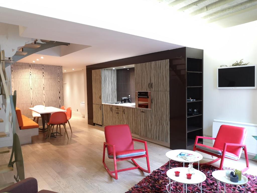 a living room with red chairs and a table at Beautiful duplex in the center of Paris in Paris