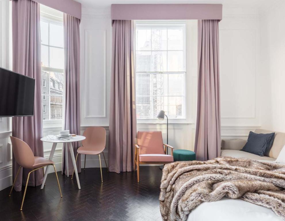 a bedroom with a bed and a table and chairs at The Moorgate by COVE in London