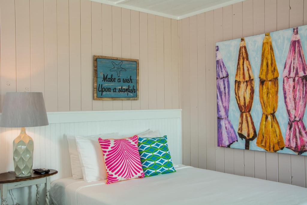 a bedroom with a bed and a painting on the wall at See Sea Motel in Kill Devil Hills