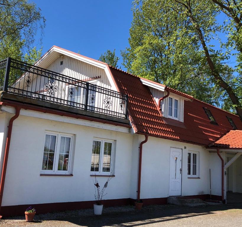 Casa blanca con balcón en la parte superior. en Gästhus La Casa en Sölvesborg