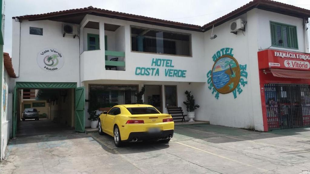 a yellow car parked in front of a building at Hotel Costa Verde in Porto Seguro