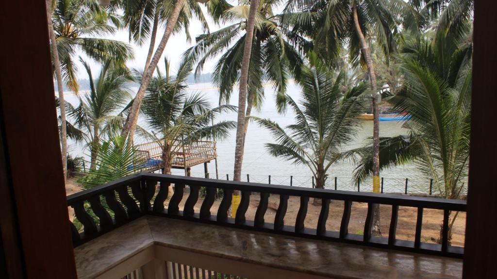 a view from the balcony of a resort with palm trees at Maleyam Homestay Riverside in Kozhikode
