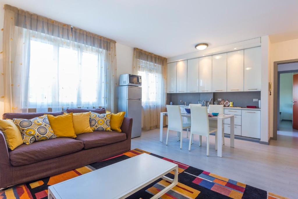 Il comprend un salon et une cuisine avec un canapé et une table. dans l'établissement La Casa del Giardin Grande, à Udine
