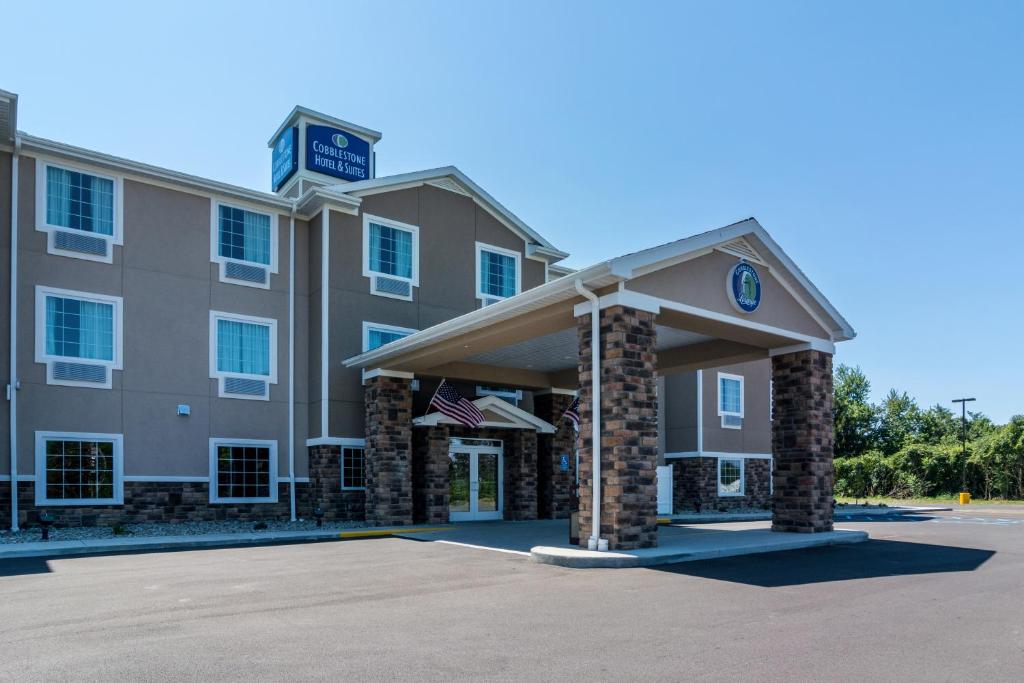 un bâtiment d'hôtel avec une horloge en haut dans l'établissement Cobblestone Hotel & Suites - Torrington, à Torrington