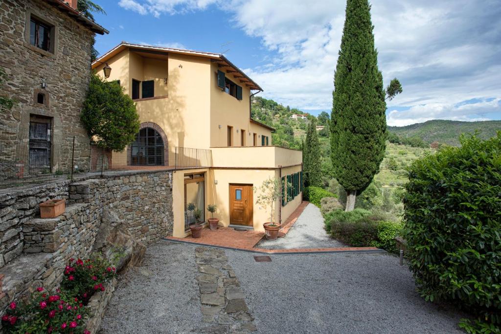 a stone house with a tree and a driveway at Villa Del Sole in Cortona