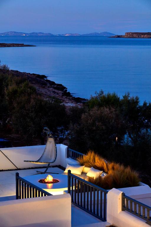 a patio with a view of the water at night at Parian Boutique Hotel in Naousa