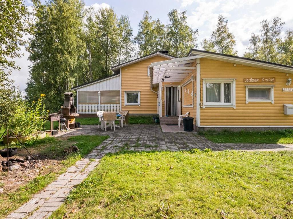 a yellow house with a patio in the yard at Holiday Home Joutsen by Interhome in Verla