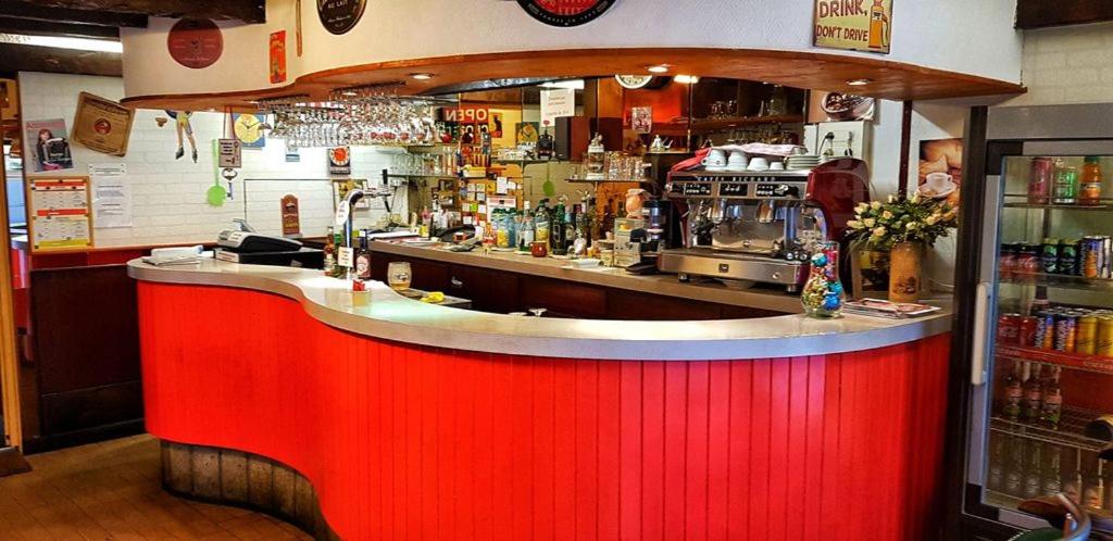 a bar in a restaurant with a red counter at Hôtel de la Gare in Morlaix