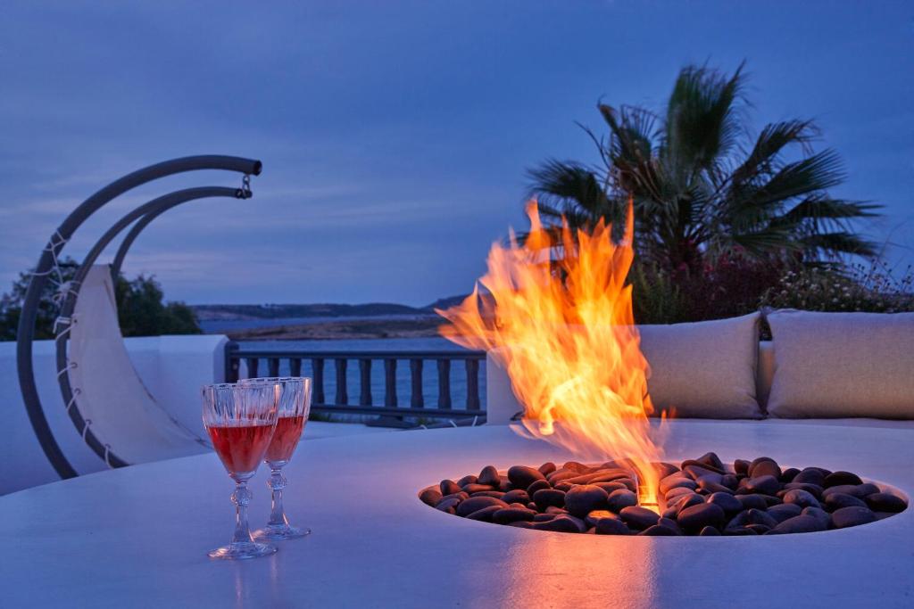a fire pit on a table with two wine glasses at Parian Boutique Hotel in Naousa