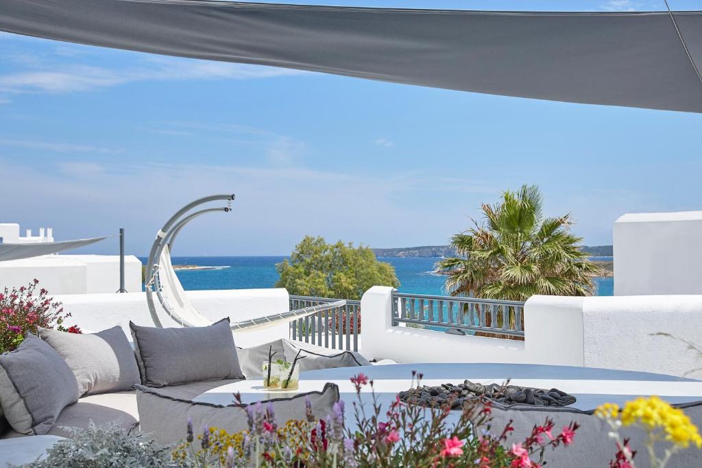 a patio with a couch and a table with a view of the ocean at Parian Boutique Hotel in Naousa