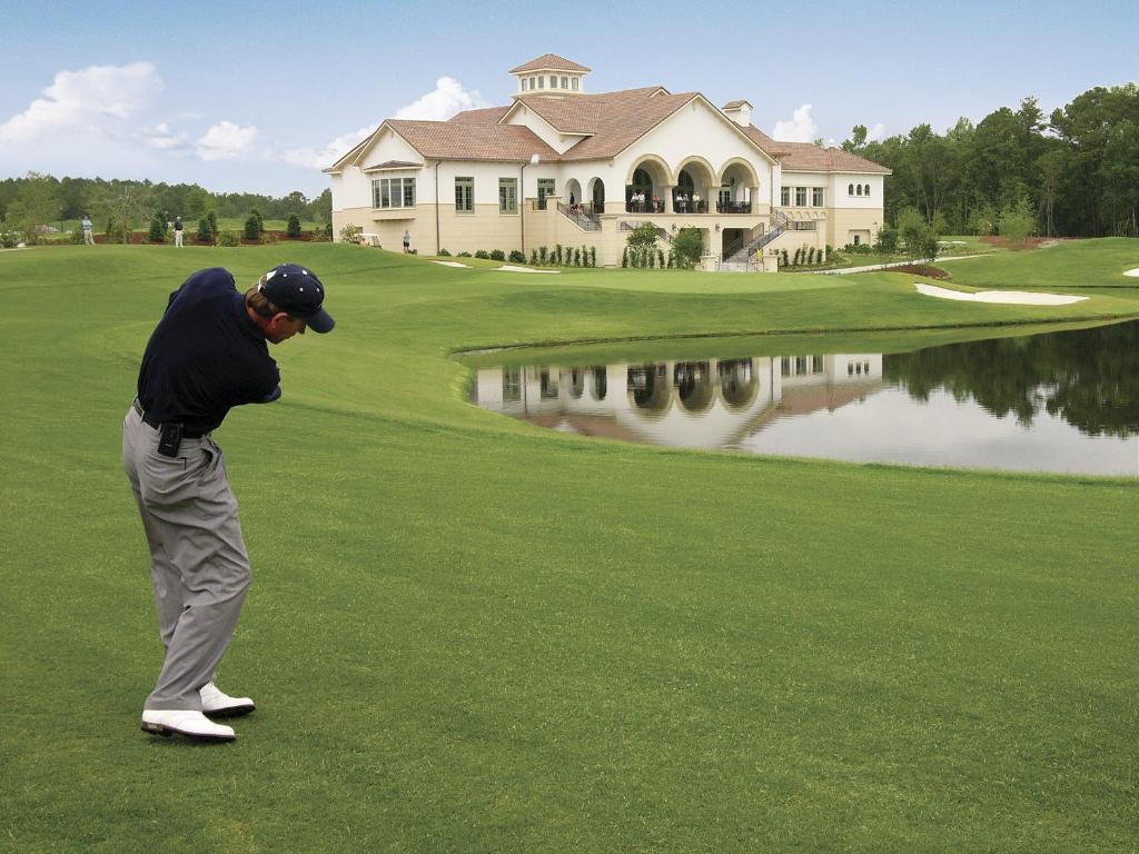 a man is playing golf on a golf course at Marina Inn at Grande Dunes in Myrtle Beach