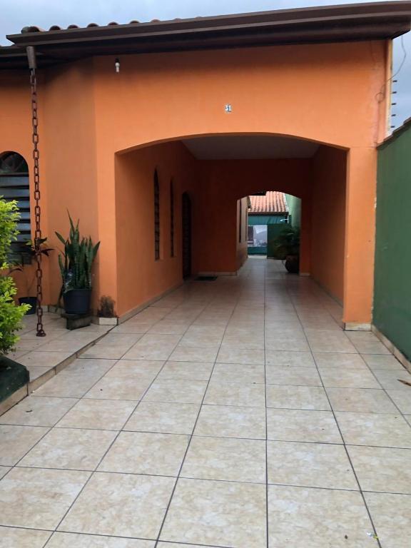 una entrada a un edificio con una pared de color naranja en casa em Martins de Sá en Caraguatatuba