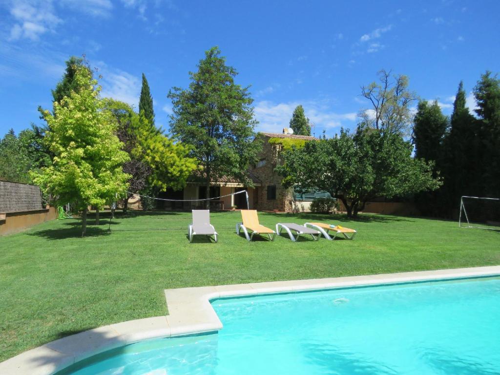una piscina en un patio con sillas y una casa en Costa Brava Apartment Casa Ana, en Camallera