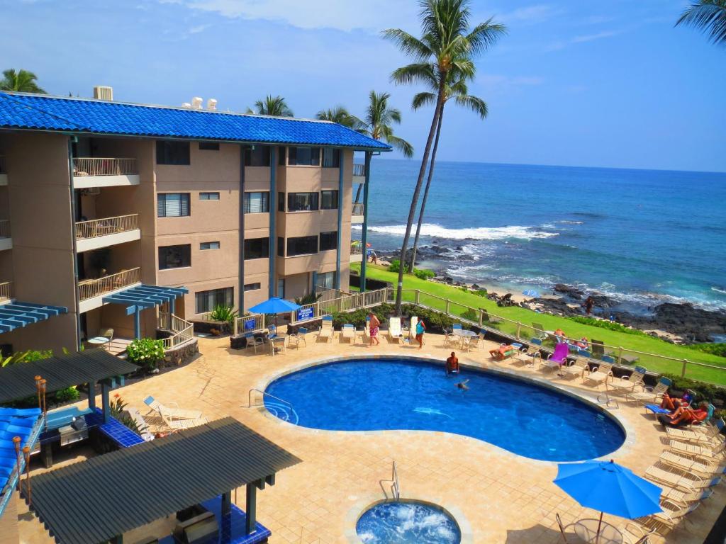a hotel with a swimming pool and the ocean at Kona Reef Resort by Latour Group in Kailua-Kona