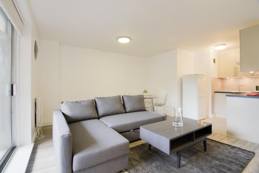 a living room with a couch and a table at Sherborne Court in London