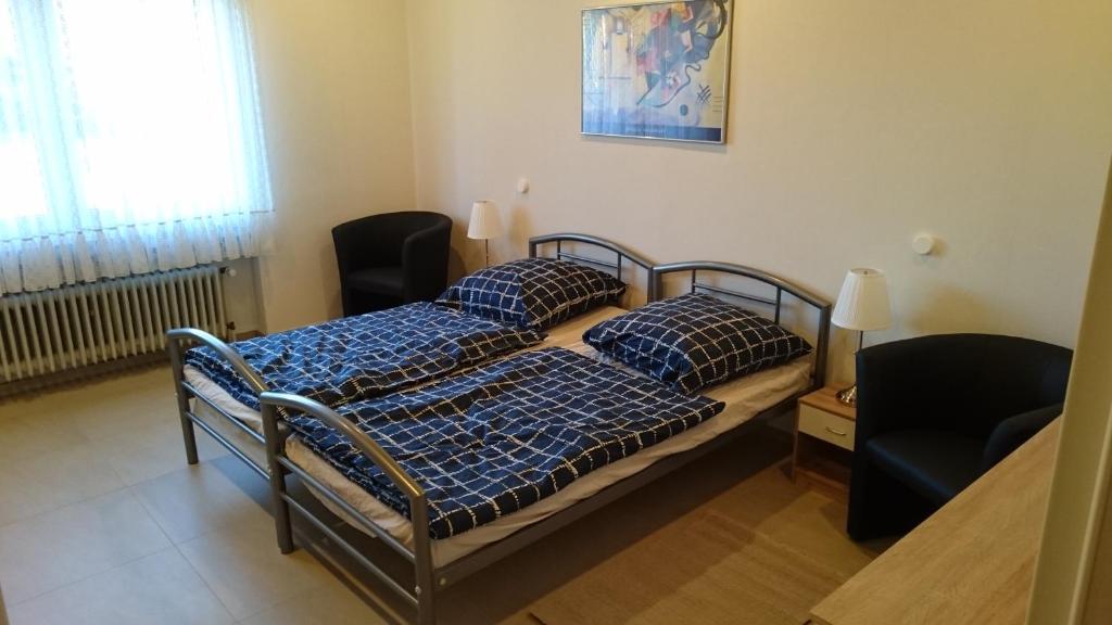a bedroom with two beds and a chair and a window at Ferienwohnung Berger in Greven