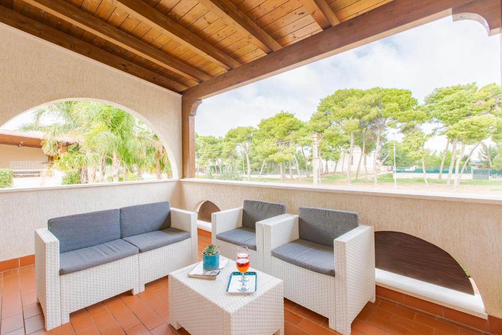 a porch with two couches and a table at Appartamento con prato inglese destro Salento in Specchiolla 