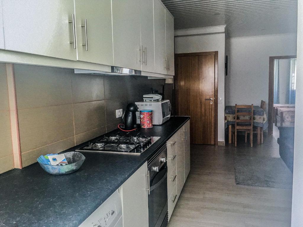 a kitchen with a stove and a microwave at Canos Verdes Apartment II in Angra do Heroísmo