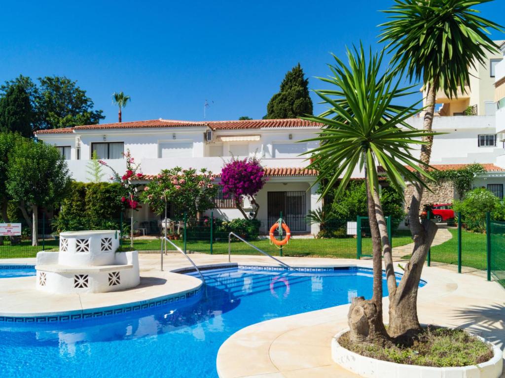 eine Villa mit einer Palme vor einem Pool in der Unterkunft Apartment Euromar by Interhome in Torremolinos
