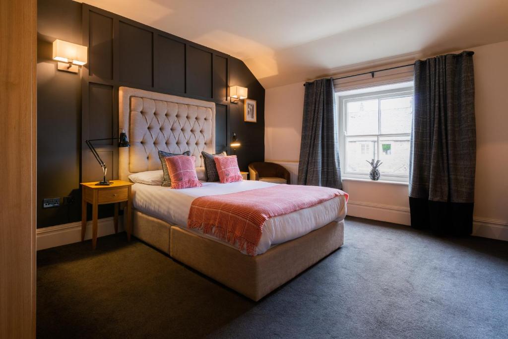 a bedroom with a large bed and a window at Derby Arms in Longridge