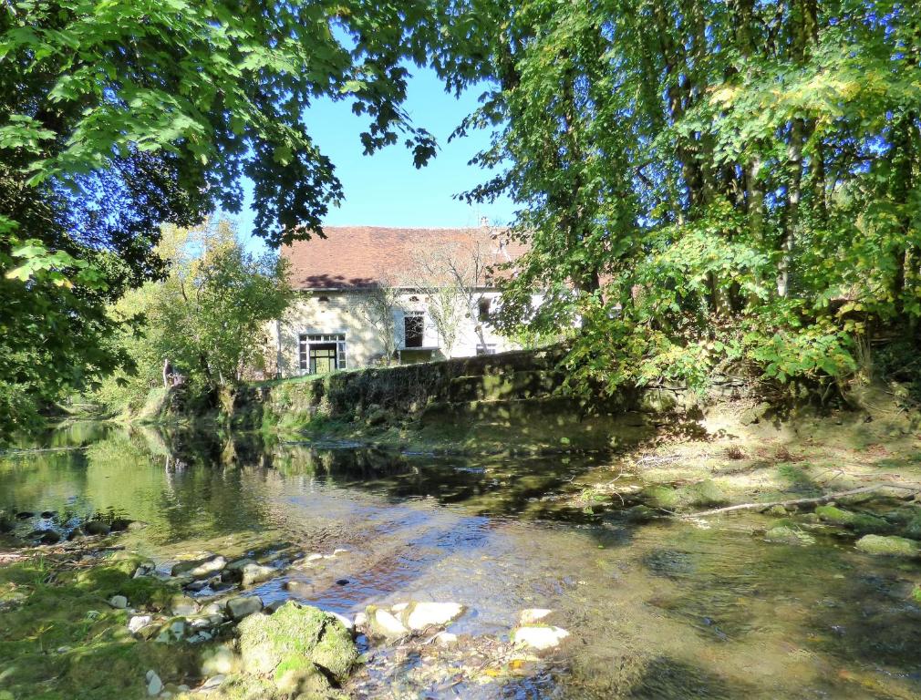 un vecchio edificio sul lato di un fiume di Côté Rivière a Nevy-sur-Seille