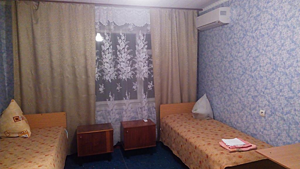 Cette chambre comprend 2 lits et une fenêtre. dans l'établissement Квартири в центрі, à Yuzhnoukrainsk 