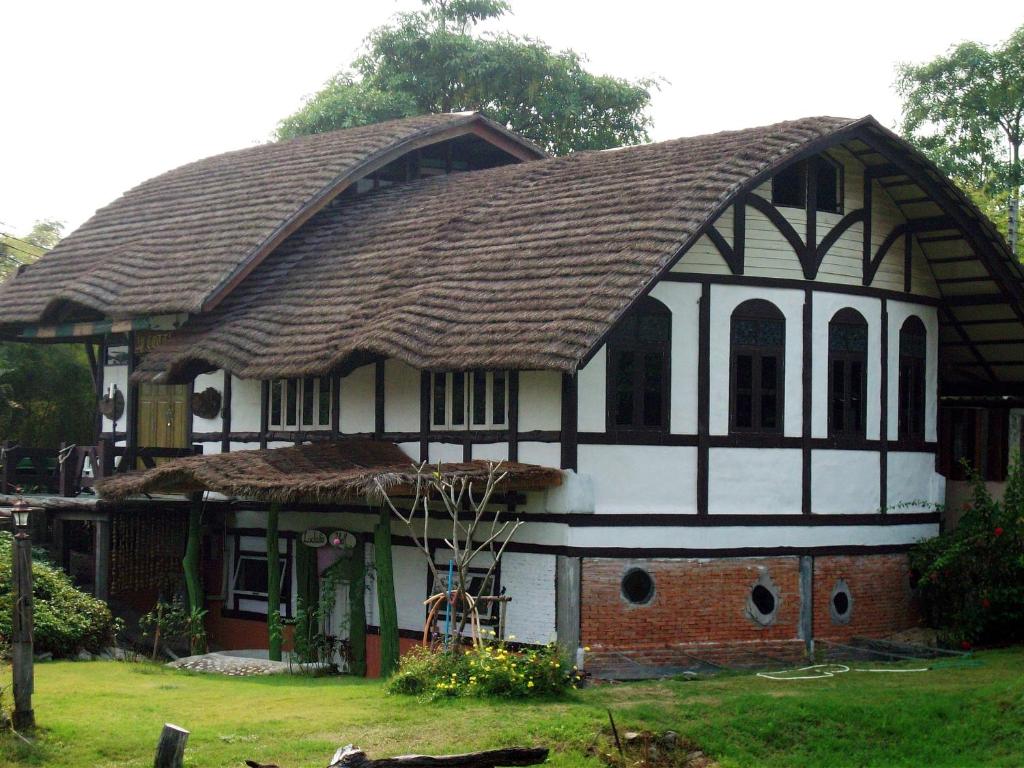 una casa con un techo grande encima en Sanita Cottage, en Chom Bung