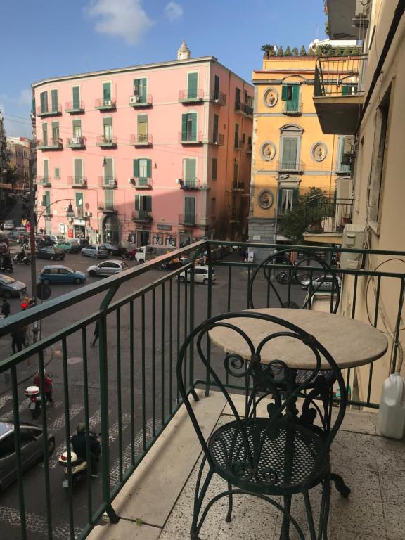 a table and chairs on a balcony with a view of a city at B&B Sansevero Naples in Naples