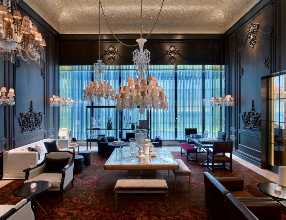 een woonkamer met een kroonluchter en een tafel en stoelen bij Baccarat Hotel and Residences New York in New York