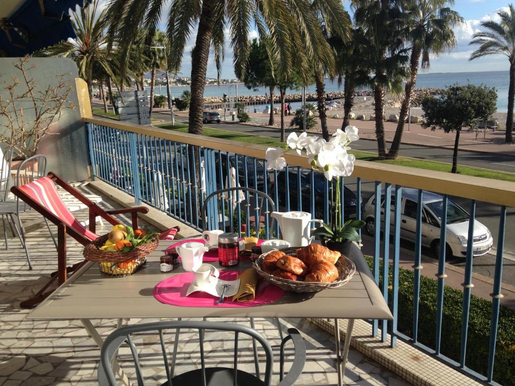 a table with food on a balcony with a view of the beach at GL La Frégate in Cagnes-sur-Mer