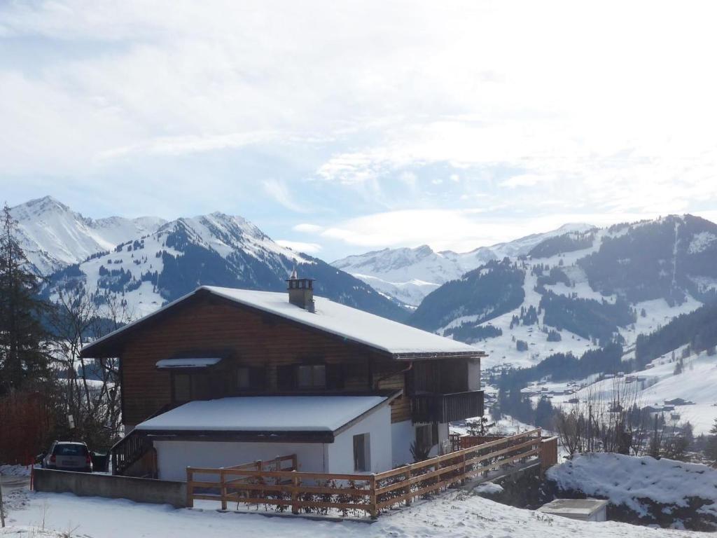 uma cabana na neve com montanhas ao fundo em Apartment Fluehüsli by Interhome em Gstaad