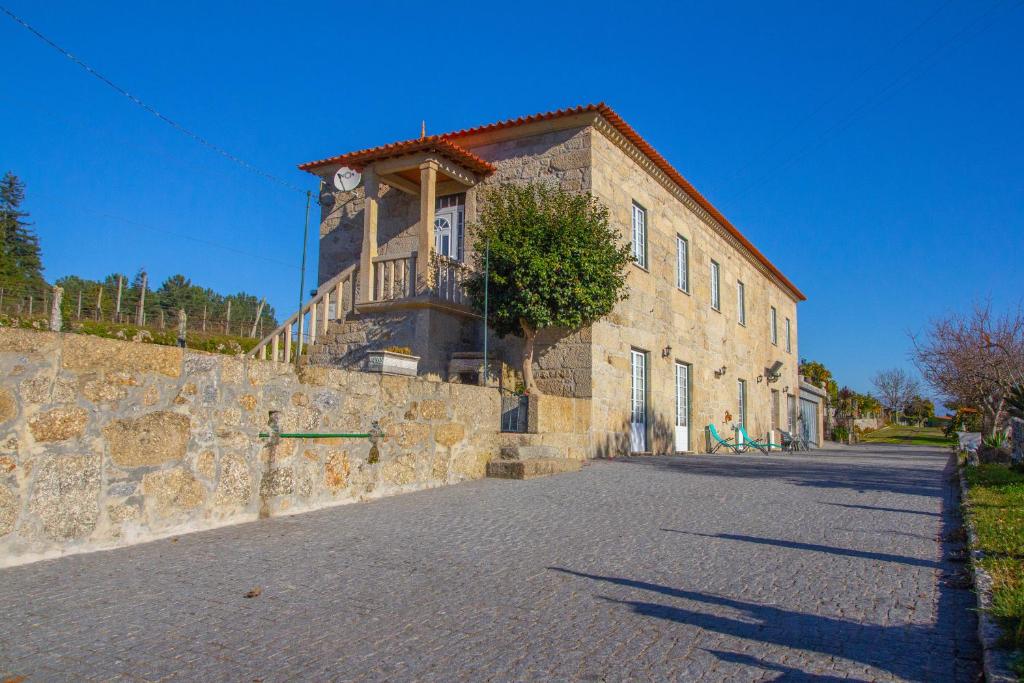 a stone building with a clock on the side of it at Casa da Tanquinha in Beiral do Lima