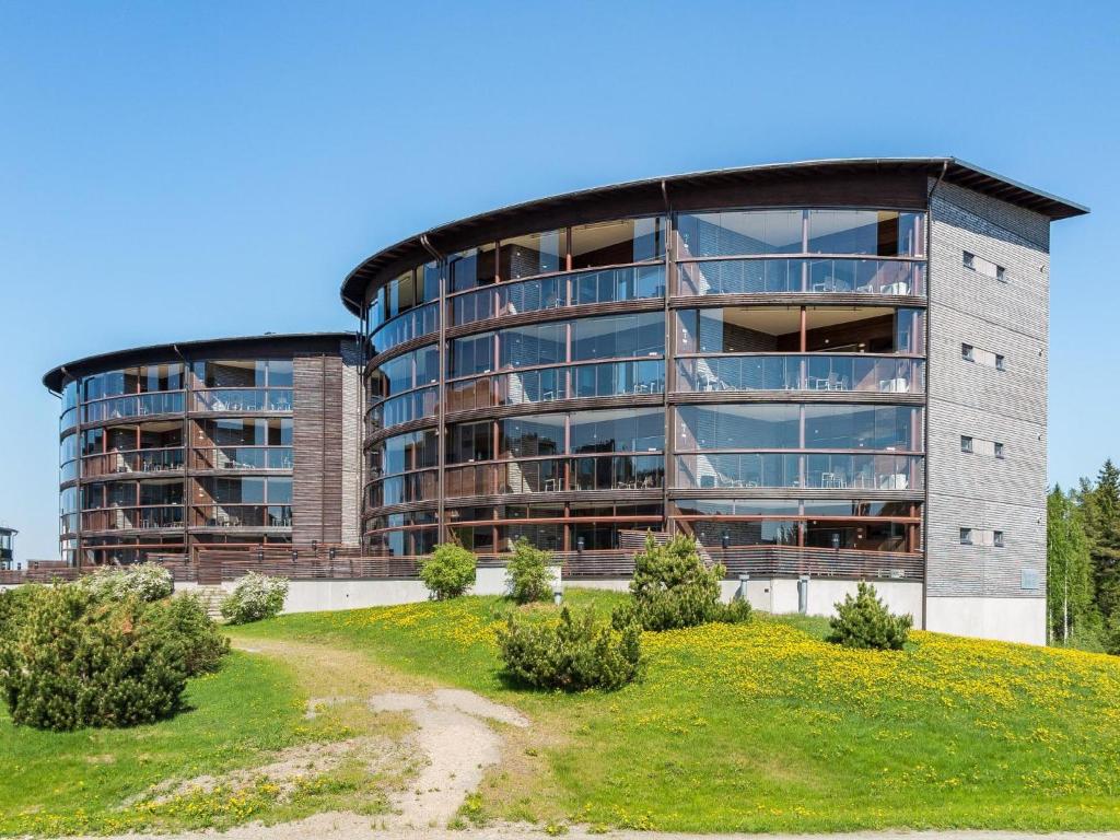 un grand bâtiment sur une colline en face d'un champ dans l'établissement Holiday Home Tahko spa suites orange a 4 by Interhome, à Tahkovuori