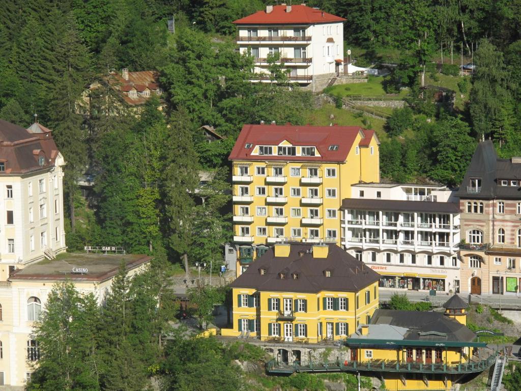 eine Gruppe gelber Gebäude auf einem Hügel in der Unterkunft Residenz Lothringen by AlpenTravel in Bad Gastein