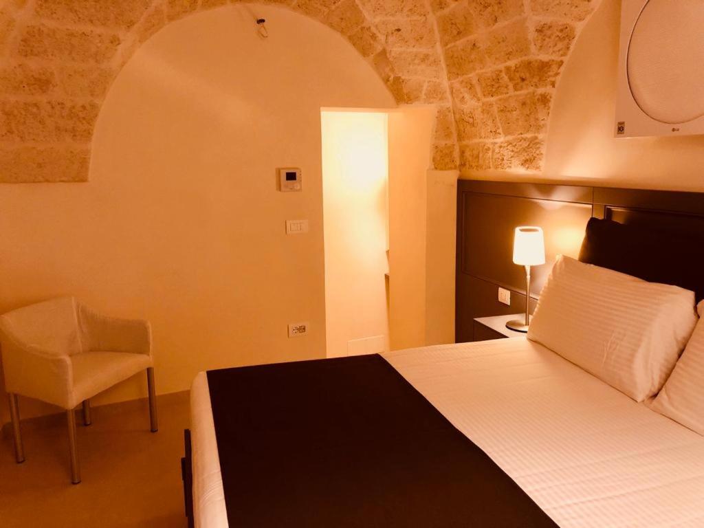 una camera d'albergo con letto e sedia di Dimora Santuzza a Ostuni